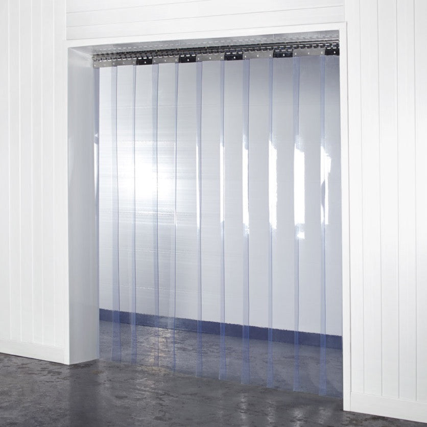 Installation view showing standard grade PVC strip curtains hanging in a pedestrian doorway.