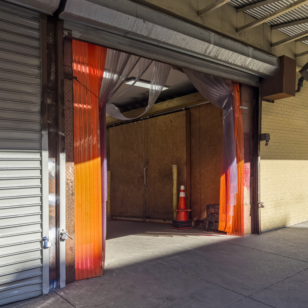 Comparison of standard and heavy-duty PVC strip curtains installed in industrial settings, highlighting optimal use for energy efficiency, durability, and cost savings.