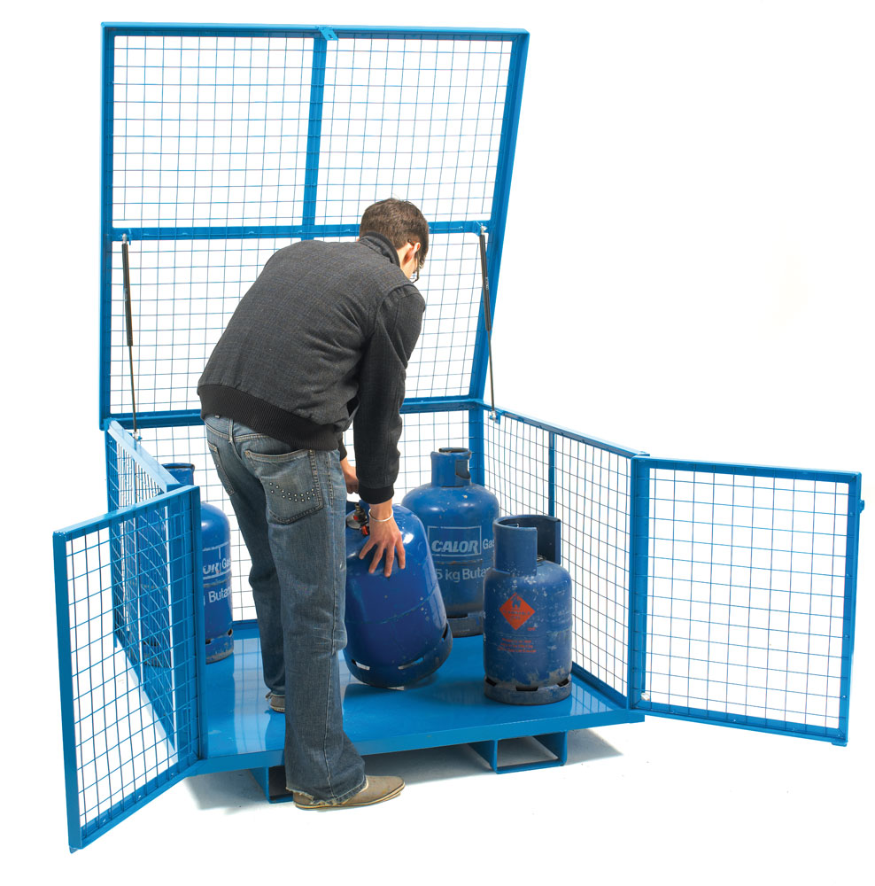 A person is seen from behind interacting with a blue metal security cage that has a lift up lid, with two blue gas cylinders inside.